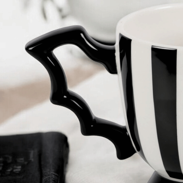 Gestreife Teetasse mit Fledermausflügel-Henkel