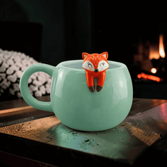 Süßer Kaffeebecher mit kletterndem Fuchs