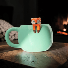 Süßer Kaffeebecher mit kletterndem Fuchs