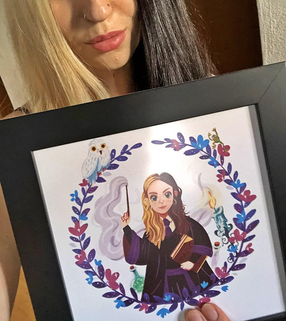 Person welche glücklich ein hochwertiges 20x20 Poster im Rahmen hochhält, bedruckt mit Zauberschüler Portrait